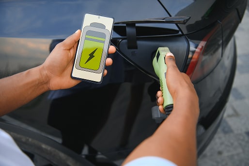 man-plugging-in-electric-car-outside-office-in-car-2025-03-14-07-54-15-utc-1-min.jpg